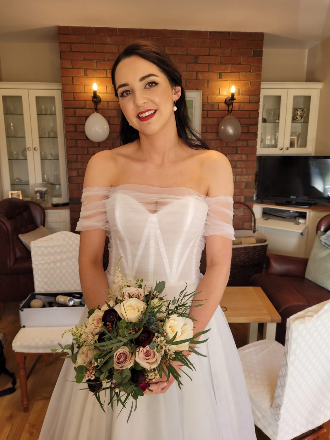 Bride with soft waves holding her bouquet, styled at INCH Hair Design