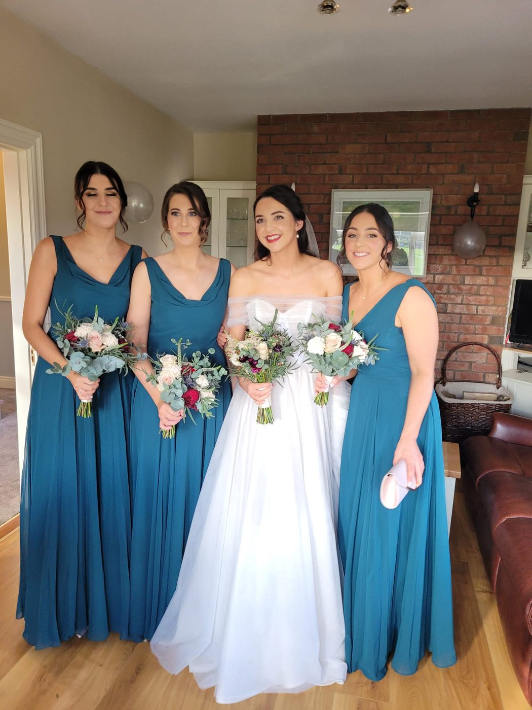 A bride with her bridesmaids in teal, all styled at INCH Hair Design