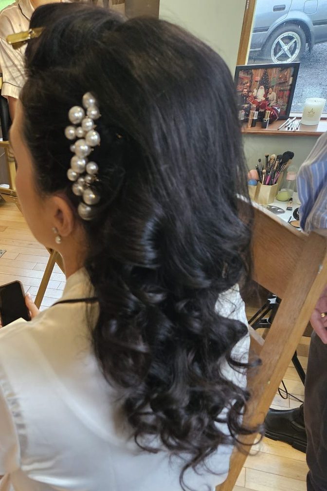 Dark bridal curls dressed with a pearl hairpiece at INCH Hair Design