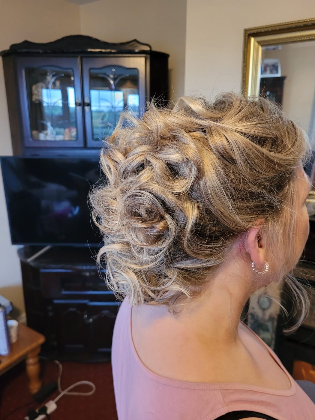 A soft, curled blonde updo dressed for a wedding at INCH Hair Design