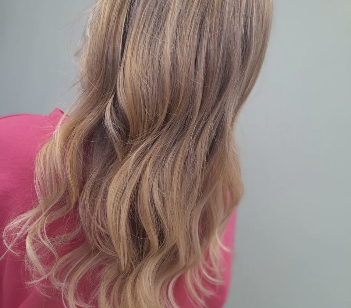 Soft blonde waves with a lived-in balayage, styled at INCH Hair Design